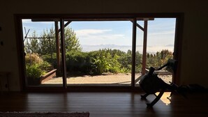 Una habitación con un gran ventanal corredero que da a un jardín.