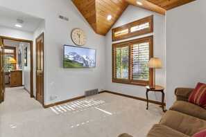 Relax in this spacious living room with a large window, flat-screen TV, and comfortable sofa.