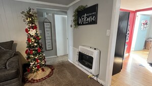 Una sala de estar con un árbol de Navidad, una chimenea y un cartel que dice 'Welcome' en la pared.