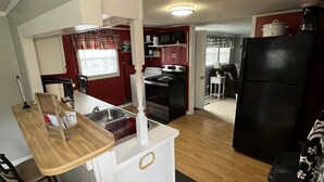 Una cocina compacta con comedor, refrigerador y microondas.