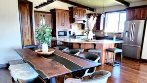 Una cocina moderna con armarios de madera, una isla grande y electrodomésticos de acero inoxidable.