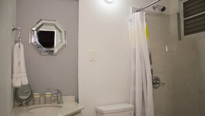 A bathroom with a toilet, sink, and shower.