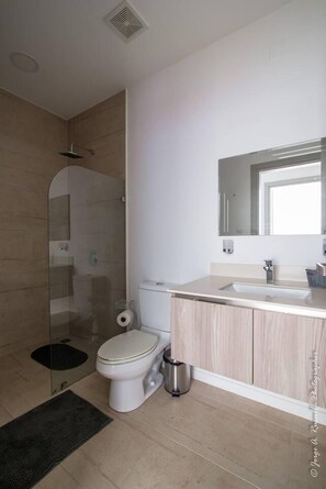A modern bathroom with a shower, toilet, and sink. - Beautiful Small Three Bedroom (Jacó)
