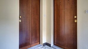Une paire de portes à double battant en bois, dotées de poignées en laiton, est placée à l’entrée d’un bâtiment.