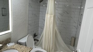 A bathroom with a toilet, sink, and shower area. - Five minutes from disney world! perfect for family sleeps up to 5-6 with balcony (Orlando)