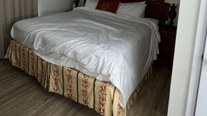 A hotel room with a large bed, wooden headboard, and a painting on the wall. - Five minutes from disney world! perfect for family sleeps up to 5-6 with balcony (Orlando)