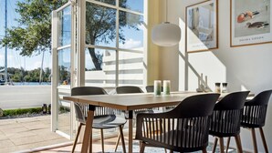 A dining area with a table and chairs, a hanging light fixture, and framed artwork on the wall. - Stunning home in Ebeltoft with sauna (Ebeltoft)