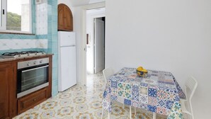 Une cuisine équipée d’une cuisinière, d’un four et d’une table recouverte d’une nappe colorée.
