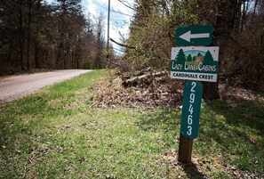A directional sign for Lazy Lane Cabins and Cardinals Crest with a green arrow pointing left.