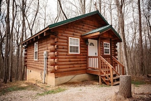 A log cabin with a porch and a staircase.