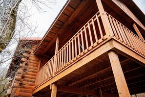 A wooden log cabin with a balcony.