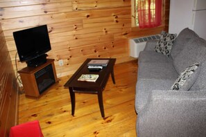 Relax in this inviting living room with a comfortable sofa, flat-screen TV, and a cozy reading nook.