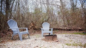 Two Adirondack chairs and a fire pit in a natural setting. - Lazy Lane Cabins - Buckeye (Logan)