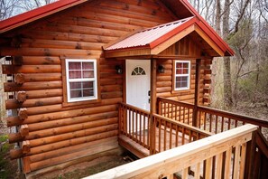 Eine Blockhütte mit Veranda und Tür.