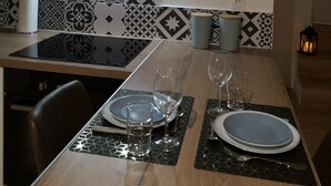Una cocina moderna con encimera negra, salpicadero estampado y una calavera de vaca montada.