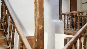 Una escalera de madera con barandilla que conduce a una puerta.
