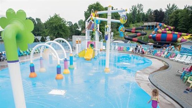 Een waterpark met een zwembad, glijbanen en een speelgedeelte.