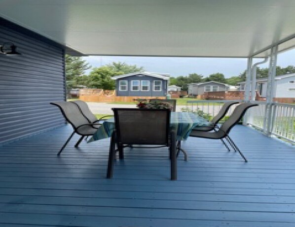 A covered patio with a table and chairs, overlooking a residential area. - Perfect hideaway at Sherkston Shores (Port Colborne)