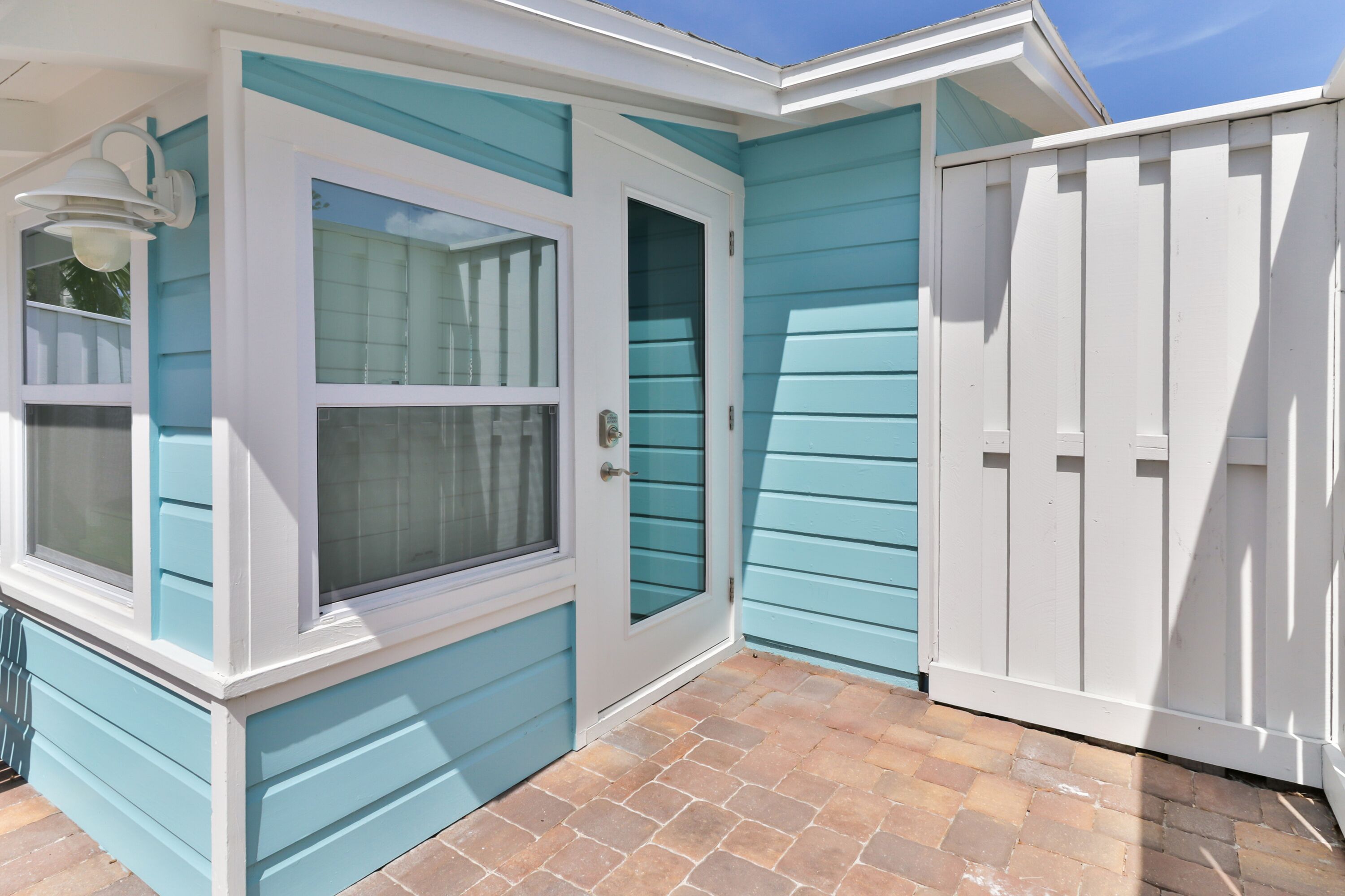 A house with a blue exterior, a white door, and a white garage door.