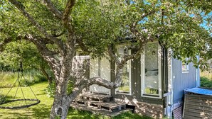 A small house with a porch, a swing, and a wooden deck. - 1 bedroom nice home in Varberg (Varberg)