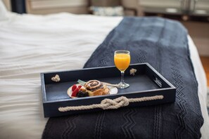 A tray with breakfast items on a bed.
