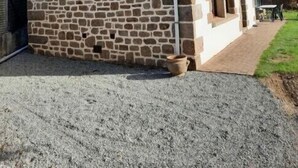 Um edifício de pedra com telhado inclinado e chaminé.