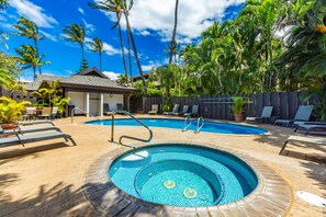 A swimming pool with a tiled edge, surrounded by lounge chairs and a wooden deck. - Cozy stylish condo in sunny South Maui (Kihei)