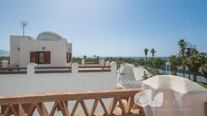 A white building with a dome and a flat roof, overlooking a coastal area with palm trees and a clear sky. - PUSHE Village Playa Granada Beach & Golf 2 (Motril)