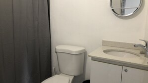 Une salle de bain avec des toilettes, un lavabo et un miroir.