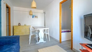 A room with a dining table, chairs, a sofa, a TV, and a wardrobe. - 3 bedroom cozy apartment in Sueca (Sueca)