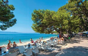 Enjoy a serene beachside setting with a clear view of the sea and a distant coastline.