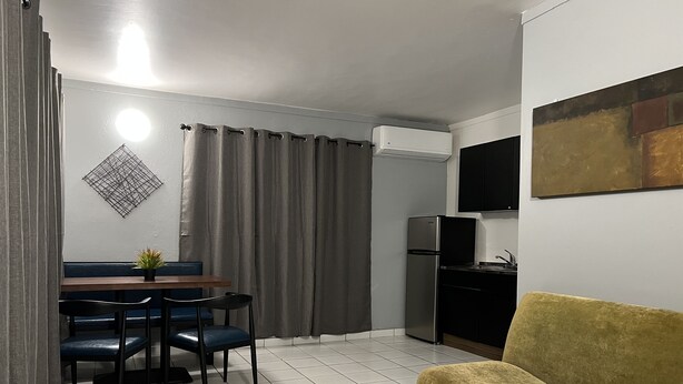 A compact living space with a dining area, kitchenette, and a sofa.