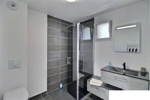 Een bad/douchecombinatie, een haardroger, handdoeken, toiletpapier