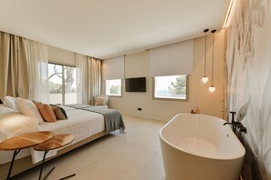 Una camera da letto moderna con un letto grande, una vasca e un televisore.