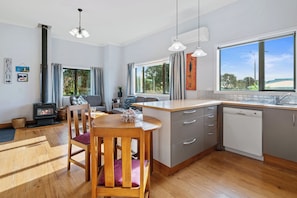 Una cocina moderna con una isla central, armarios grises y un amplio ventanal con vistas al exterior.