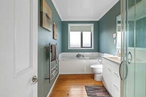 Un baño con bañera, inodoro y ventana.
