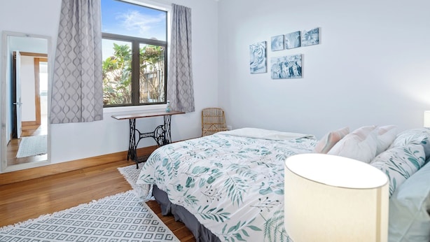 A bedroom with a bed, a desk, and a window with curtains. - Ekhaya - New Plymouth Holiday Home (New Plymouth)