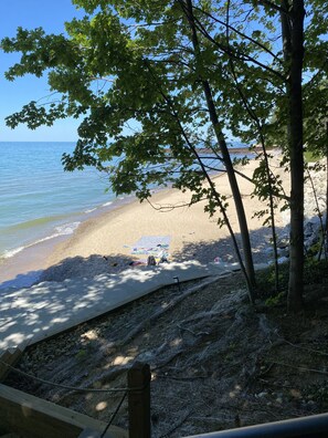 Una spiaggia con spiaggia sabbiosa, una piccola tenda e una zona rocciosa con alberi.