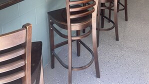 A seating area with wooden chairs and a long table against a wall with a floral mural. - Recently Updated 3 Bedroom House, Fire Pit, Hot Tub, Game Room (New Buffalo)