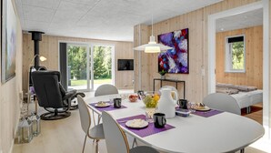 Un comedor moderno con una mesa blanca, individuales morados y una variedad de platos.
