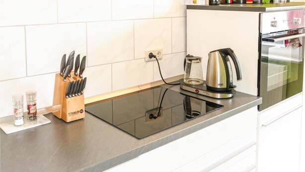 A kitchen with a black induction cooktop, a kettle, and a knife block. - Nice home in Kalbe/ Milde -Kakerbec with WiFi (Kalbe/ Milde -Kakerbec)