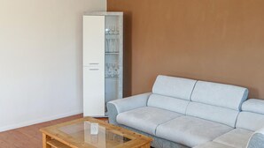 A living room with a light grey sofa, a tall white cabinet with glass doors, and a wooden coffee table. - Nice home in Kalbe/ Milde -Kakerbec with WiFi (Kalbe/ Milde -Kakerbec)