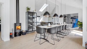 Une cuisine moderne dotée d’un îlot central, d’une cuisinière intégrée et de luminaires suspendus.