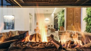 A modern living room with a fireplace, sofas, and a dining area. - Prora Solitaire Sunny Suite (Binz)