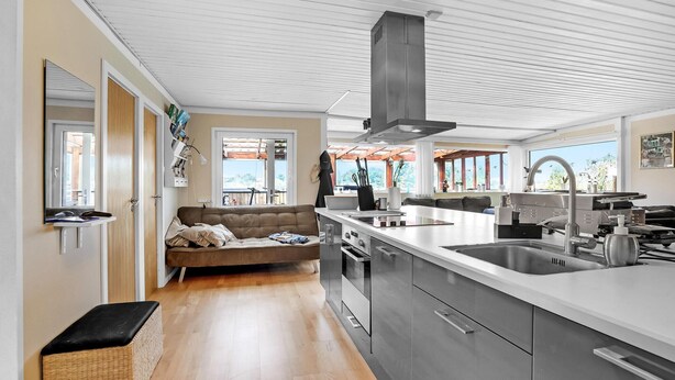 A modern kitchen with a central island, stainless steel appliances, and a large window offering a view of the outdoors. - 3 bedroom lovely home in Karrebæksminde (Karrebæksminde)