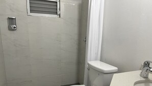 A bathroom with a toilet, a shower area, and a sink. - Private Apartment close to everything you need! (San Juan)