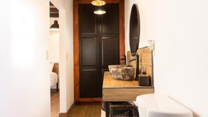 A bathroom with a wooden vanity, a large basin, a mirror, and a toilet. - VALLE LIFE (Valle de Guadalupe)