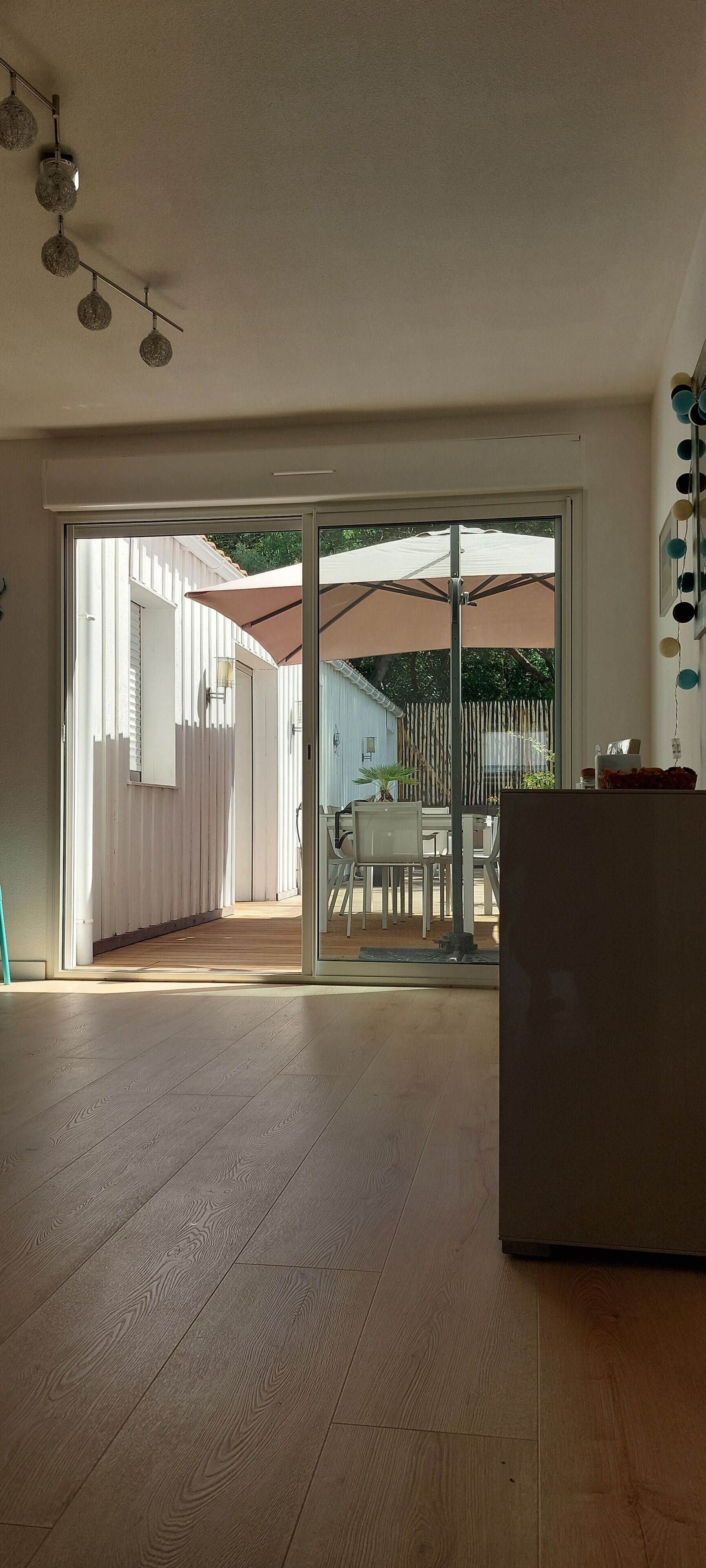 An open-plan living space with a sliding glass door leading to an outdoor patio area.