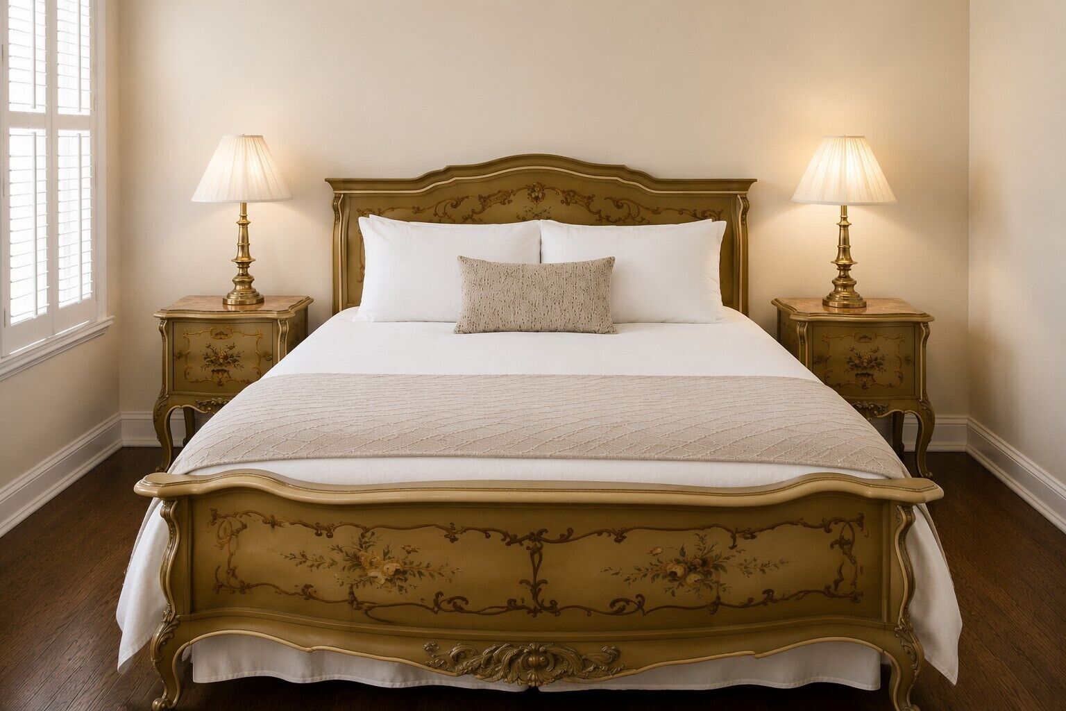 A bed with a gold frame, two bedside lamps, and a window with blinds.