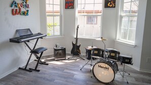 Ein Musikstudio mit Keyboard, E-Gitarre und Schlagzeug.